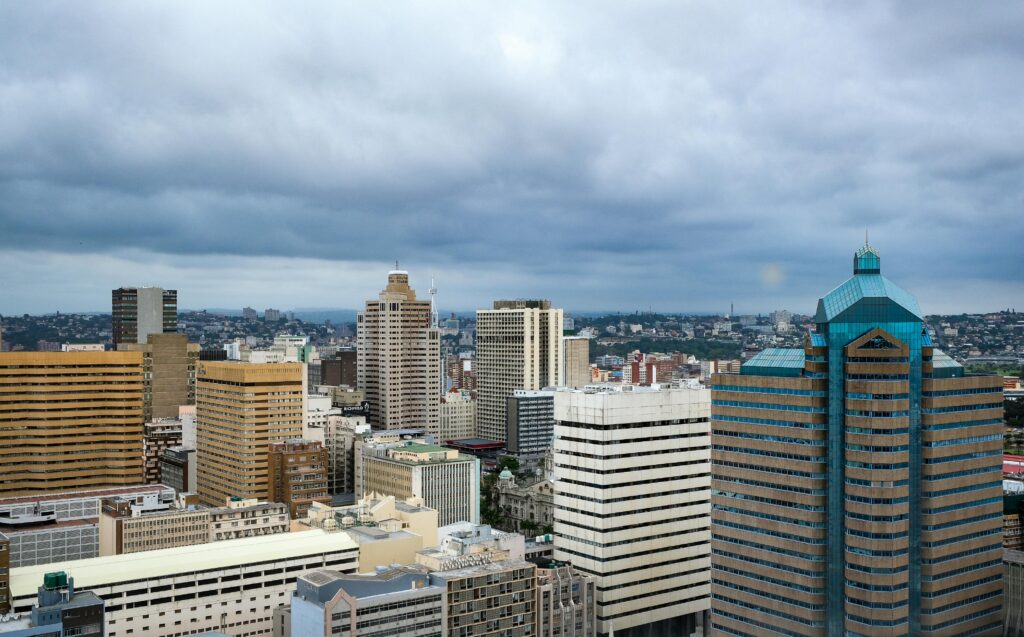 A stunning aerial view of Durban's modern skyline with high-rise buildings and an overcast sky.